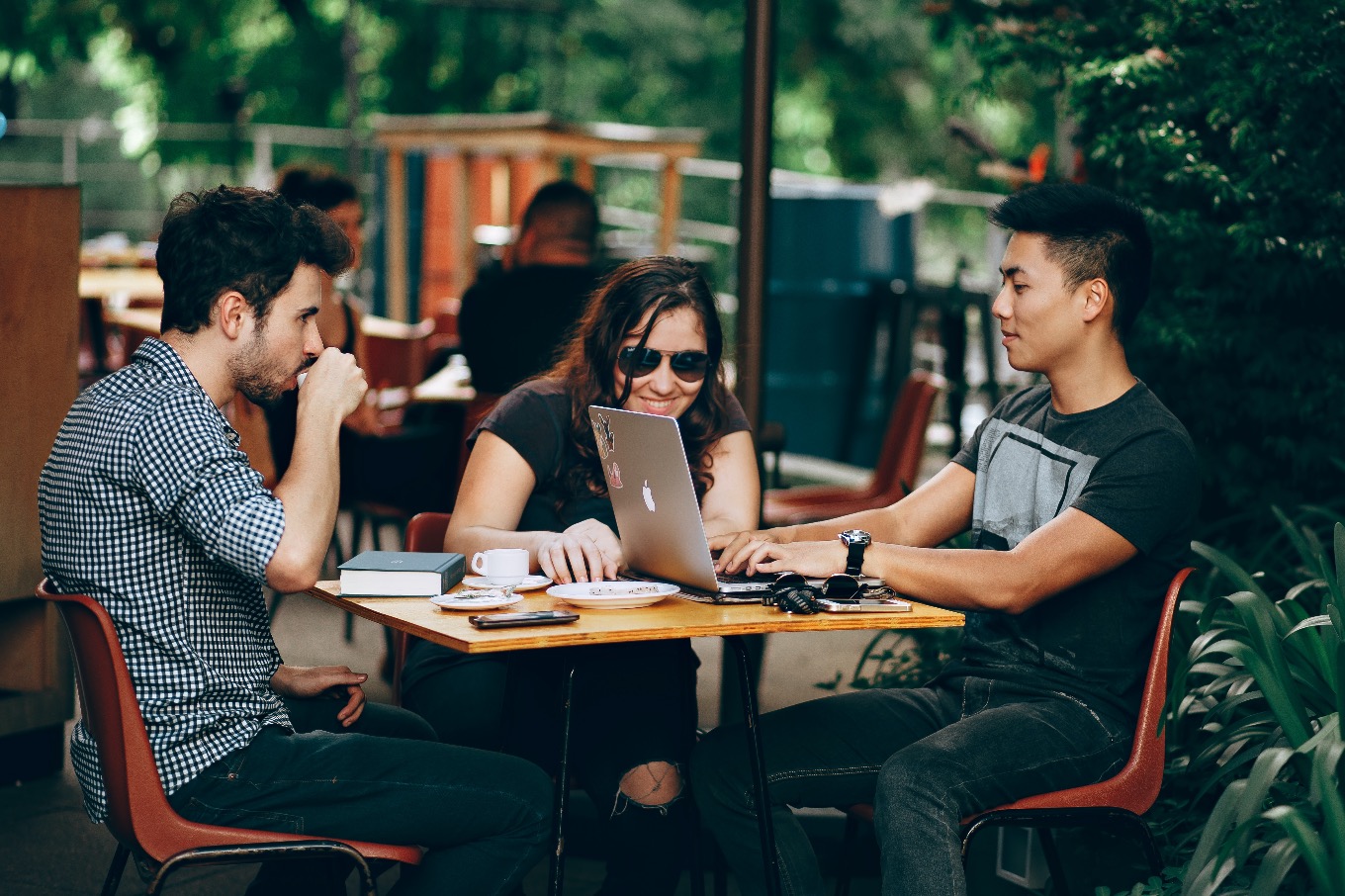 students sitting at tables, talking outside